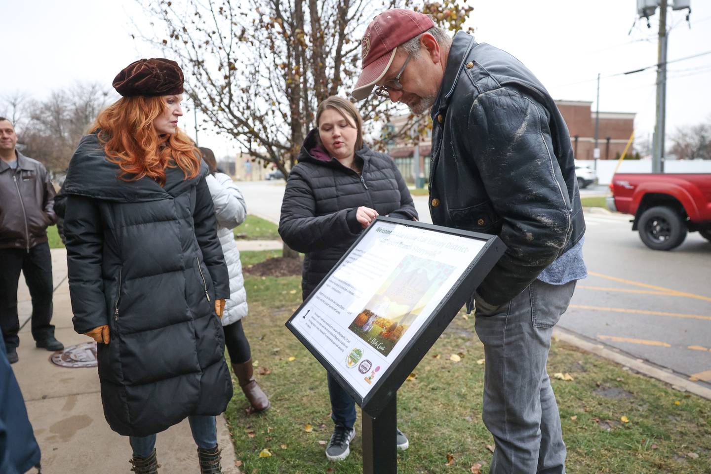 Wendy Streit, summer arts chair, left, Evangeline Stephenson, Lockport Library branch manager, and Lockport Mayor Steve Streit looks at the StreetWalk plaque outside the Lockport Library.