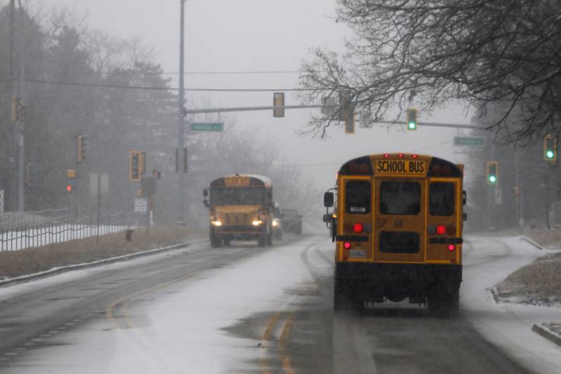 School basses navigate the weather as they travel on Walkup Road on Wednesday, Feb. 12, 2025, in Crystal Lake as a winter storm starts to bring heavy snow to the McHenry County area.