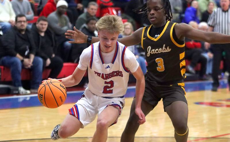 Dundee-Crown’s Shane Demarsh, left, works around Jacobs’ Malachi Bell in varsity boys basketball on Friday, Dec. 12, 2025, at Dundee-Crown High School in Carpentersville.
