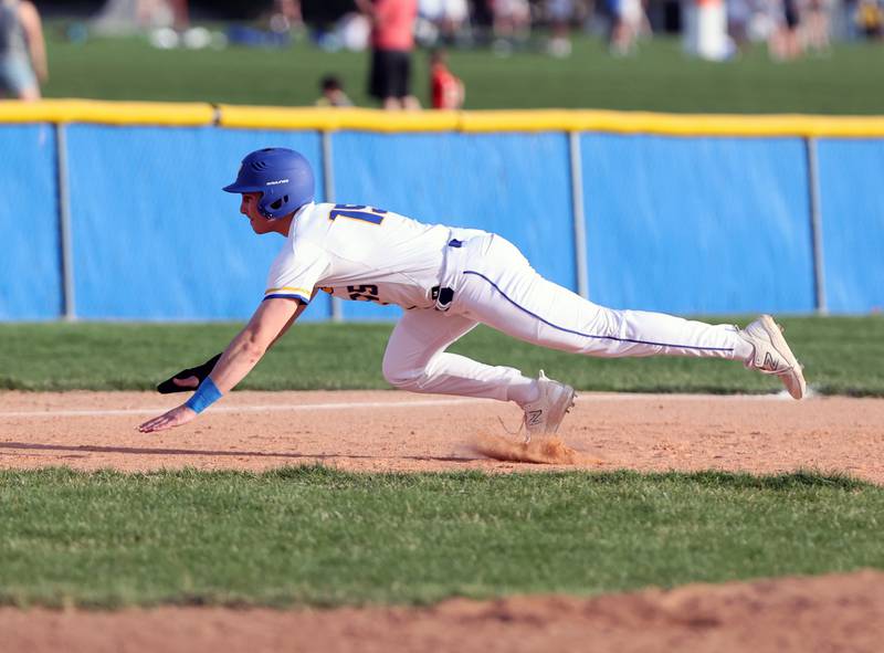 Lyons Township's James Georgelos (15) starts a slide into third during the boys varsity baseball game between Lyons Township and Downers Grove North high schools in Western Springs on Tuesday, April 11, 2023.