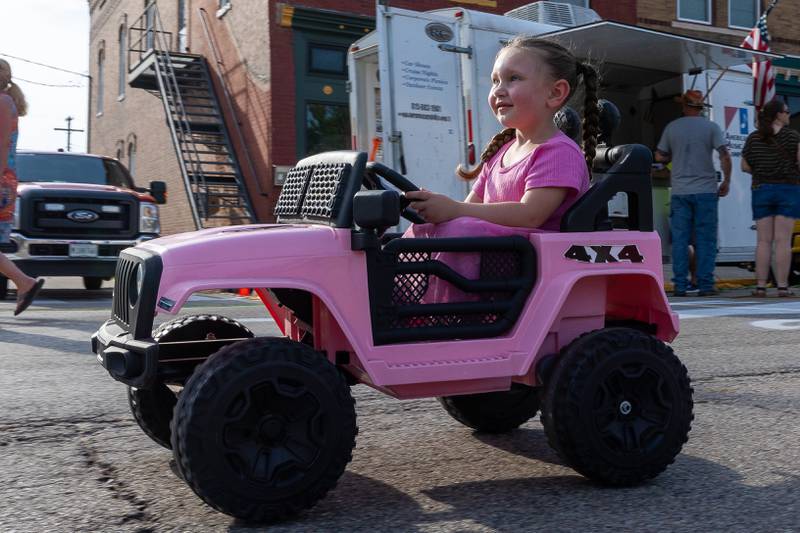 Makenzie Riley drives a Power Wheel down the street at the 20th annual Cruise Night on Friday, August 8, 2025, on Main Street in Marseilles.