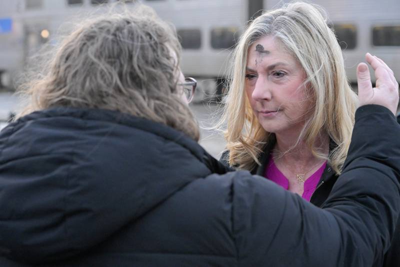 Fiona Dean of Batavia receives ashes from  Pastor Christine Webb of Table Church at the Geneva train station on Wednesday, Feb 18, 2026.