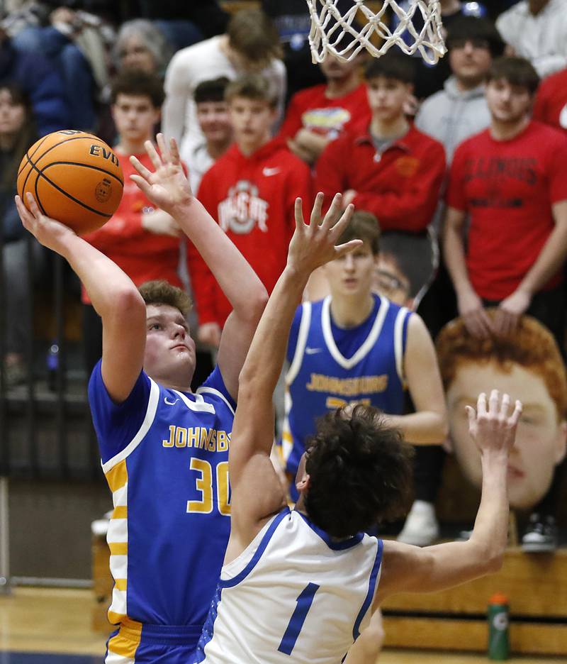 Johnsburg's Jayce Schmitt shoots the ball over Woodstock's Collin Greenlee during a Kishwaukee River Conference basketball game on Friday,  Feb. 14, 2025, at Woodstock High School.