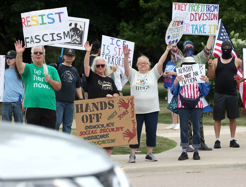 Protesters wave at cars honking in support Saturday, July 4, 2025, at the corner of Main and State Streets in front of the DeKalb County Courthouse in Sycamore during a "No Kings" rally to voice their displeasure with President Donald Trump.
