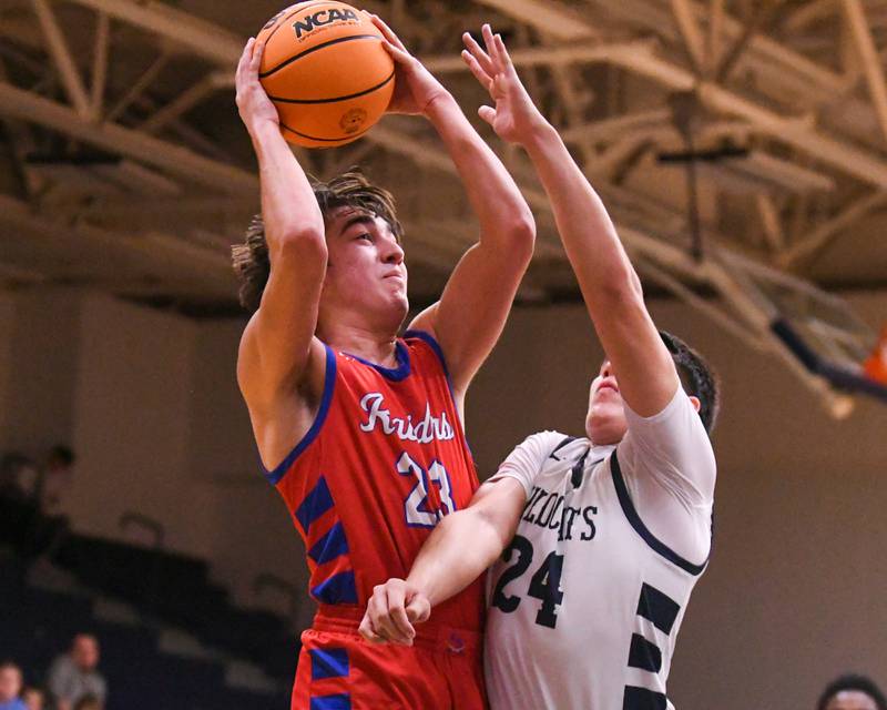 Glenbard South's Joey Villa (23) gets a shot off and makes a basket while being defended by West Chicago's Oliver Muñoz (24) during the game on Friday Jan. 3, 2025, held at West Chicago High School.