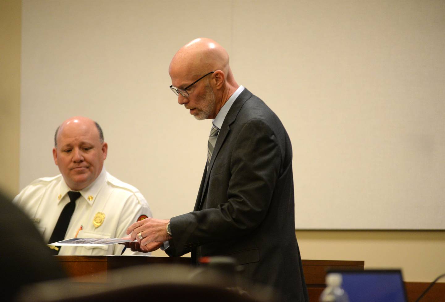 Mount Morris Fire Chief Rob Hough looks at a photo as he answers questions from Ogle County State's Attorney Mike Rock at the Ogle County Judicial Center in Oregon on Tuesday, March 19, 2024.