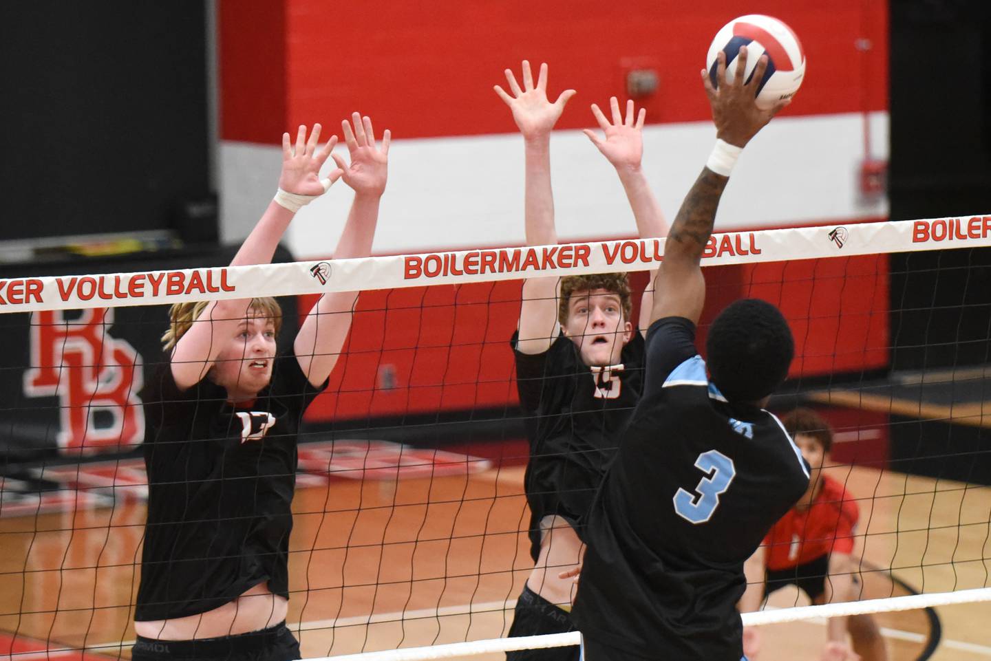 Bradley-Bourbonnais' Jason Parker, left, and Owen Kilpatrick, center, defend a hit from Kankakee's Jamon Barlow during a game at Bradley-Bourbonnais Thursday, April 9, 2026.