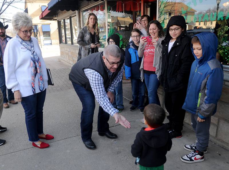 Darren Bailey, a Republican candidate for Illinois governor, reaches his hand out to a child Thursday, March 3, 2022, during a stop at the Little Chef Restaurant in McHenry. Bailey, who is one of several Republicans expected to run for a governor, spoke to a room full of people during the first of four scheduled campaign stops Thursday.