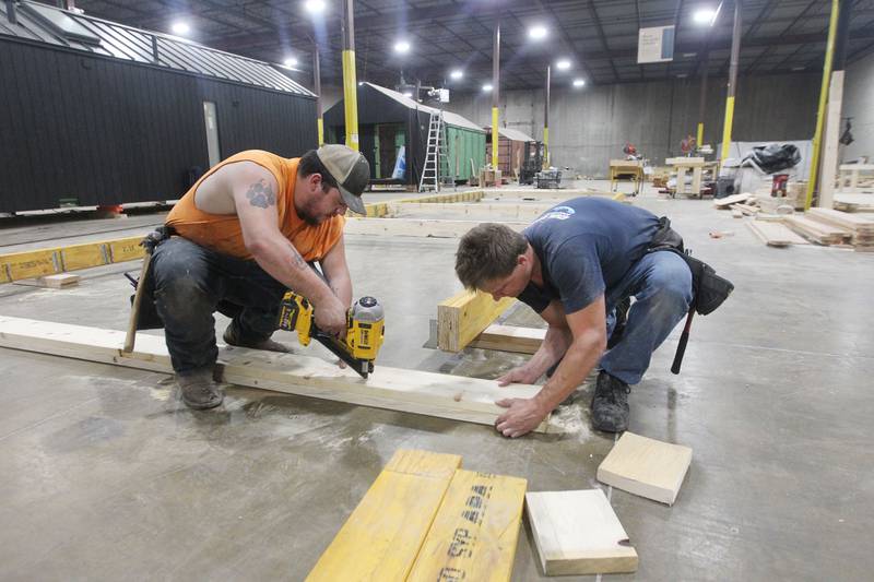 Jack Beucher, of Silver Lake, Wis., framer, and Joe Levinskas, of Lake Villa, plumber, work on framing the foundation for a Milla Long, the largest unit prefabricated tiny home with 456 sq. ft., in the factory at PrefabPads LLC in Waukegan on July 17th, 2023.
Image by Candace H. Johnson for Shaw Local News Network