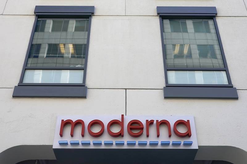 FILE - In this Dec. 15, 2020, file photo, a sign for Moderna, Inc. hangs on its headquarters in Cambridge, Mass.  Moderna's experimental COVID-19 vaccine that combines its original shot with protection against the omicron variant appears to work, the company announced Wednesday, June 8, 2022.  COVID-19 vaccine makers are studying updated boosters that might be offered in the fall to better protect people against future coronavirus surges.(AP Photo/Elise Amendola, File)