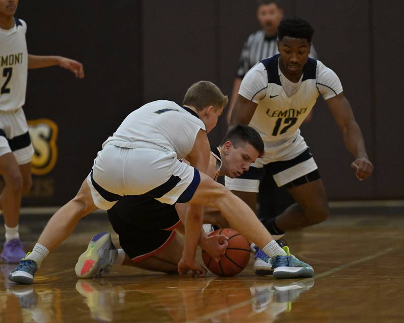 Lemont's Matas Castillo (1) and Minooka's Silas Slavik (10) wrestle for a loose ball in the WJOL Basketball Tournament on Monday, November 21, 2022, at Joliet.