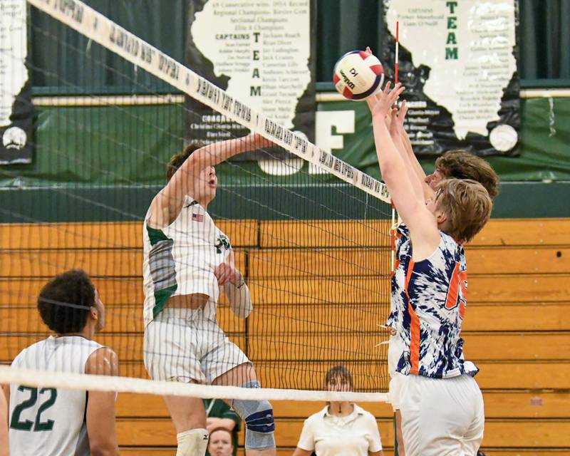 Glenbard West's Casey Maas, left, spikes the ball past Oak  Park-River Forest's Wesley Kochendorfer (15) during the game on Tuesday April 16, 2024, held at Glenbard West High School.