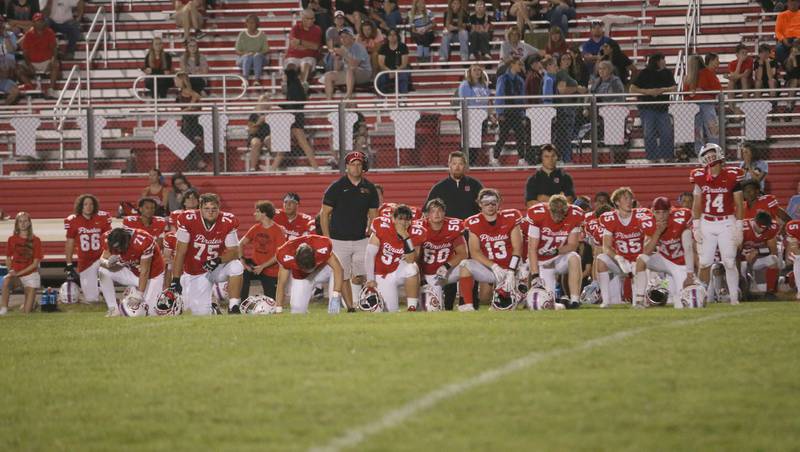 Ottawa football players take a knee as quarterback Mark Munson is carried off of the field by ambulance in the third quarter on Friday, Sept. 12, 2025 at King Field.