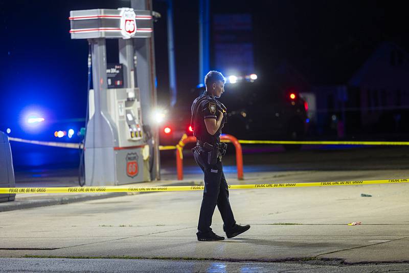 Sterling officer Jamie Russell investigates the scene of a shooting Tuesday, May 28, 2024 at Phillips 66.