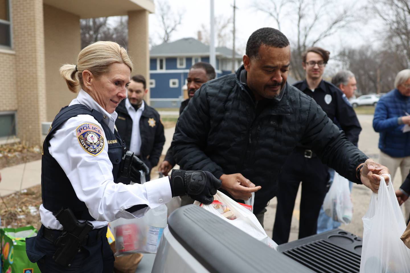 Deputy Sherrie Blackburn and Deputy Richard Brown grab bags of food donations from the police department’s “Pack the Paddy Wagon” food drive at the Salvation Army in Joliet.