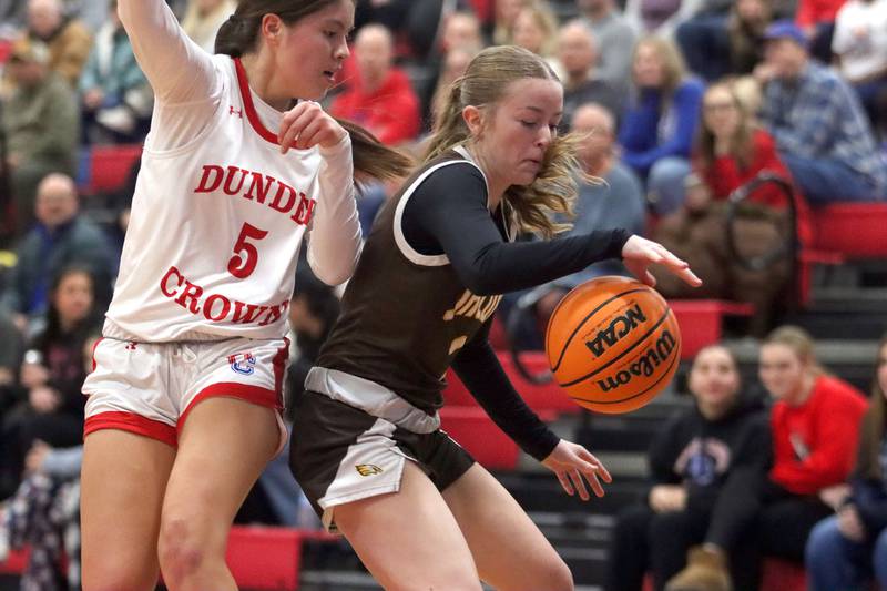 Jacobs’ Sienna Ryan, right, handles the ball as Dundee-Crown’s Ashley Castro defends in varsity girls basketball on Friday, Dec. 12, 2025, at Dundee-Crown High School in Carpentersville.