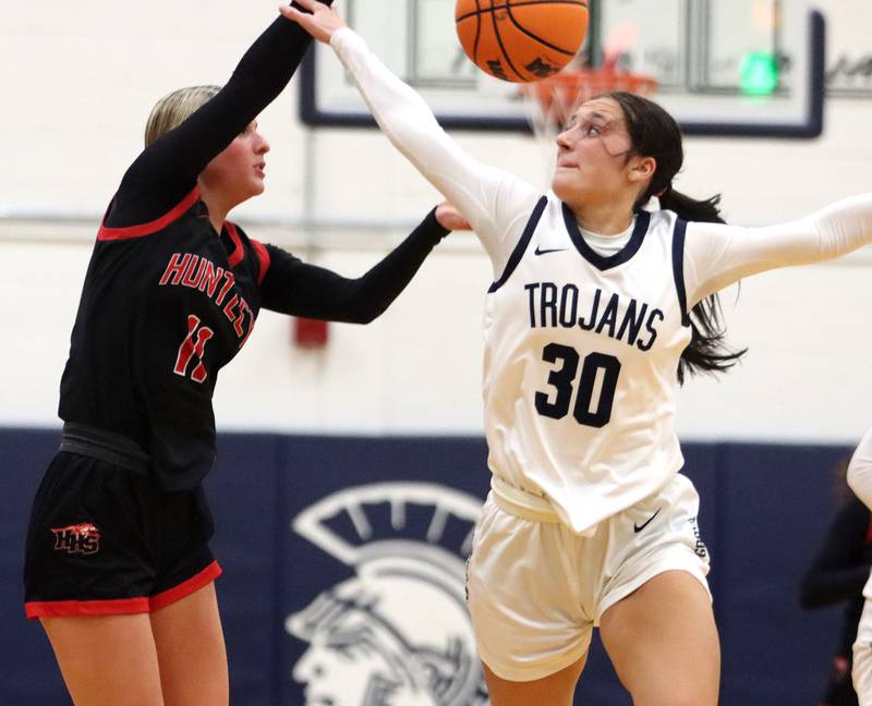 Huntley’s Anna Campanelli, left, dishes the ball past Cary-Grove’s Samantha Skerl in varsity girls basketball on Friday, Jan. 24, 2025, at Cary-Grove High School in Cary.