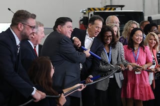 Governor JB Pritzker, center left, and Marc Bedard, CEO of Lion Electric, cut an electric cord in place of a ceremonial ribbon at the grand opening of the Lion Electric manufacturing facility on Friday, July 21st, 2023 in Joliet.