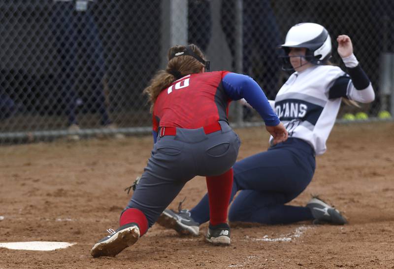 Dundee-Crown’s Faith Dierwechter tags out  Cary-Grove’s Megan Koski as she slides into home plate during a Fox Valley Conference softball game Monday, April 4, 2022, between Cary-Grove and Dundee-Crown at Cary-Grove High School.