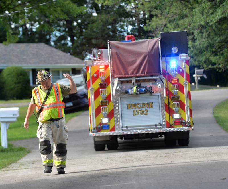 Mt. Morris Fire Chief Rob Hough IV directs a fire truck down the road to a burning home at the end of a cul de sac at 540 E. Elizabeth Road, southeast of Oregon on Wednesday, Aug. 20, 2025. Mt. Morris was one of four area departments who assisted Oregon firefighters on the call.