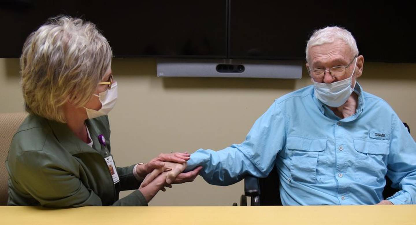Nurse Bo Kielbus clasps the hand of Jack Wilson of Burlington Tuesday as they talk about what happened in July when he went into cardiac arrest at an outpatient lab at Advocate Sherman Hospital.