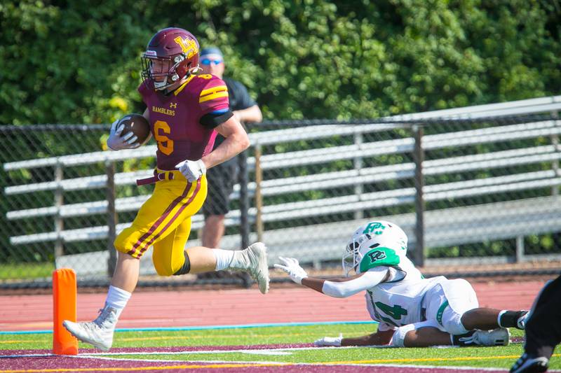 Loyola Academy quarterback Brian Dwyer (6) runs in a touchdown past a Providence Catholic defensive back Darian Bolden (24) during the football game at Loyola Academy High School on Saturday, Oct. 9, 2021. The Ramblers won, 40-0.