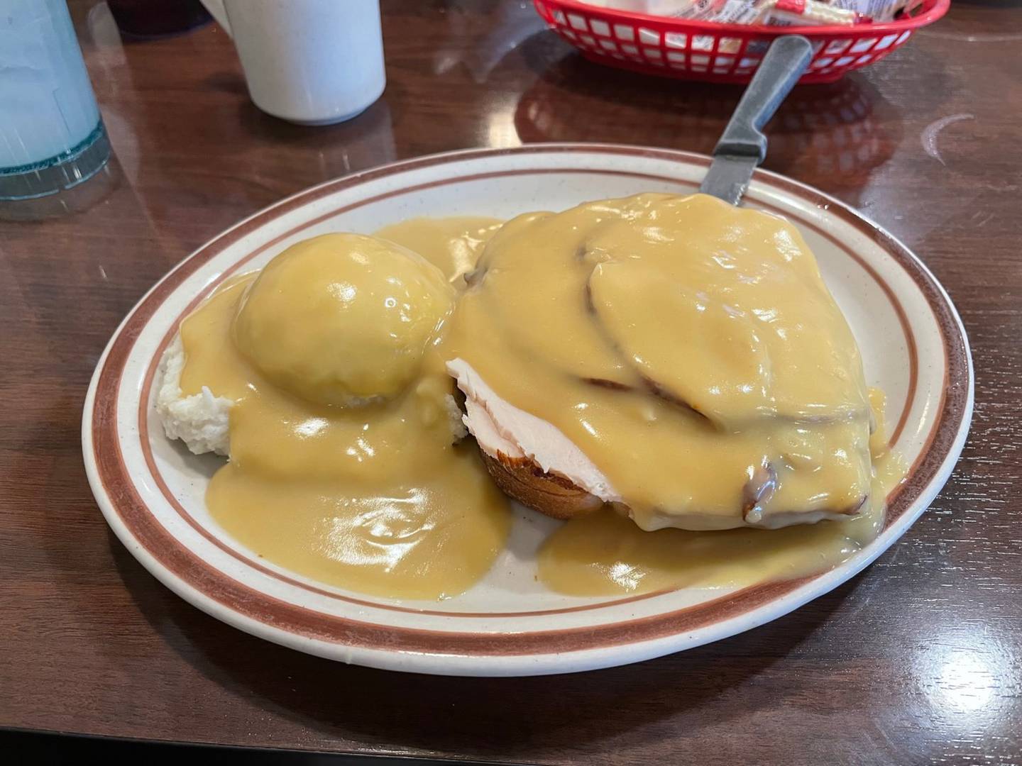 A hot open-faced turkey sandwich with mashed potatoes, served with a cup of soup, one of the menu items at Four Star Family Restaurant in Peru.