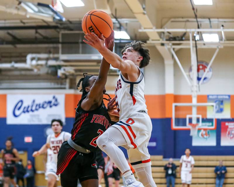 Oswego's Mariano Velasco (5) is fouled on a layup attempt during their basketball game between Yorkville at Oswego, Tuesday Dec 10, 2024 in Oswego.