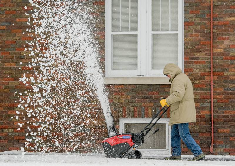 Bob Johnson clears the snow from his driveway along Lewis Street in DeKalb on Wednesday, Dec. 30, 2020.