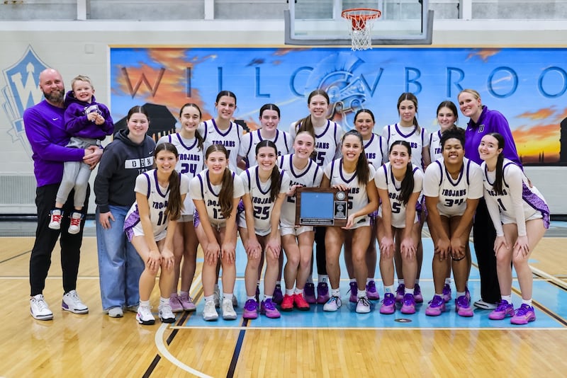 Downers Grove North's girls basketball team celebrates after winning the West Suburban Conference crossover championship.
