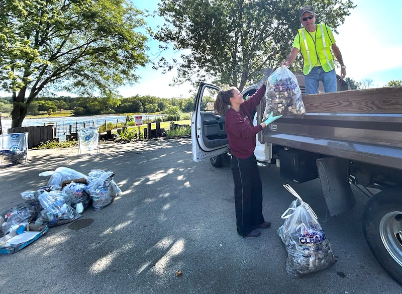 Mike Long hands a bag of trash to Melanie Cozzi during the Rock River Sweep on Saturday, Sept. 6, 2025. Volunteers collected trash from the river and its banks from Mud Creek Road to Castle Rock State Park.