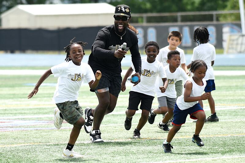 Jonathan Ward, black shirt, joyfully runs down the field with campers at the sixth annual Jonathan Ward Skills Camp at Kankakee High School Saturday, June 14, 2025.