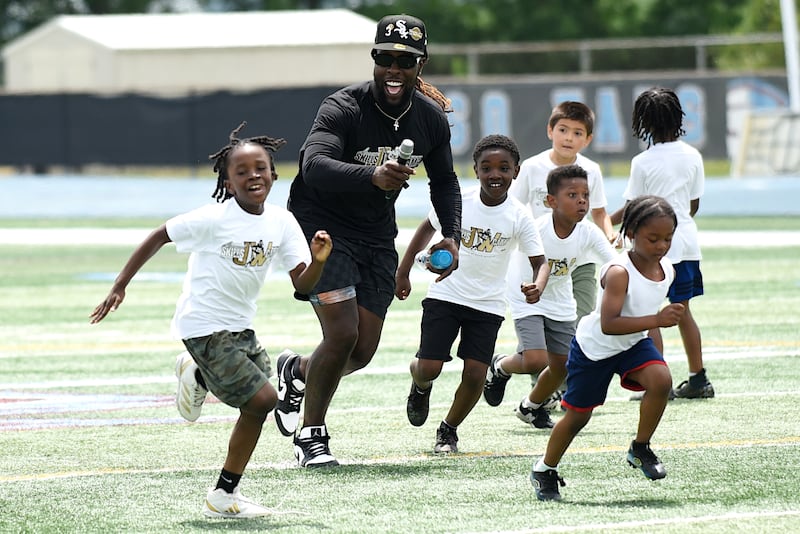 Jonathan Ward, black shirt, joyfully runs down the field with campers at the sixth annual Jonathan Ward Skills Camp at Kankakee High School Saturday, June 14, 2025.