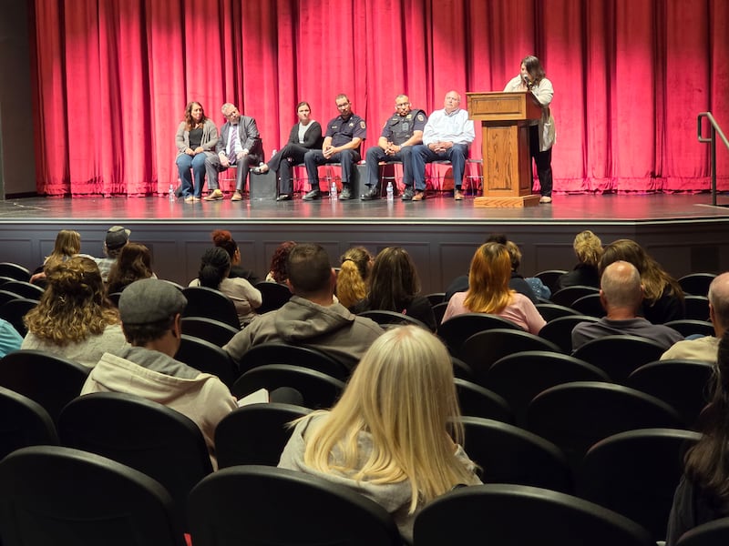 Streator Mayor Tara Bedei stands behind the lectern and speaks to a crowd of about 150 people Thursday, May 8, 2025, at the Streator High School auditorium during a town hall meeting addressing recent violence.