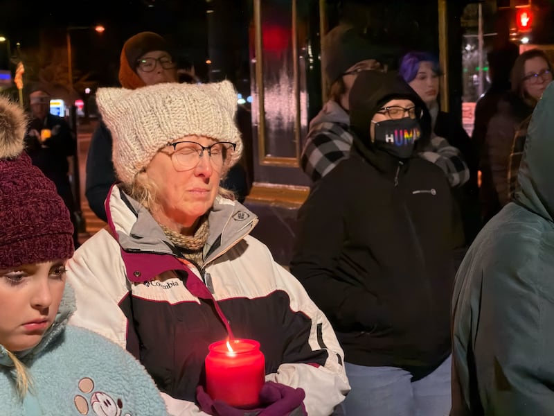 A woman closes her eyes during a moment of silence as mourners gathered for a candlelight peace vigil on Friday, Jan, 9, 2026, in downtown DeKalb. Organizers called the vigil to remember the life of Renee Nicole Good, 37, a Minnesota mother who was shot and killed by a federal immigration agent in Minneapolis on Jan. 7, 2026. Organizers said the vigil was meant to provide a peaceful place to mourn as President Donald Trump's violent immigration enforcement sweeps across the country grow more divisive.