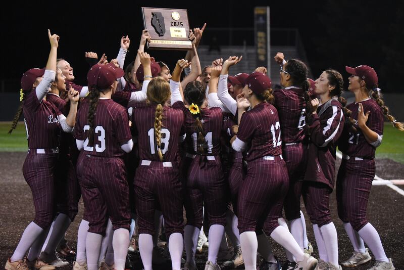 The Lockport softball team celebrates with the Class 4A Illinois Wesleyan Supersectional plaque after defeating Bradley-Bourbonnais 2-0 Monday, June 9, 2025.