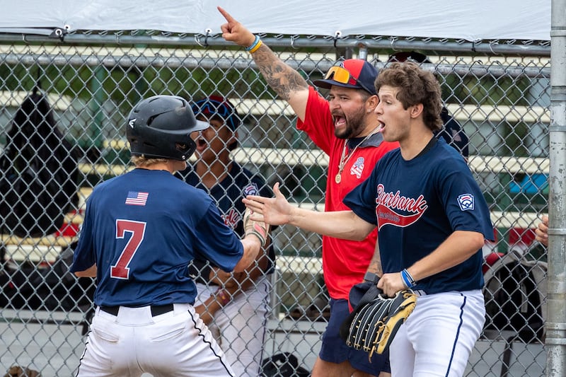 Jake Edlund (7) of Illinois celebrates scoring run with Coach Enrique Villanueva and Lucas Karczewski (11) on Thursday, July 17, 2025 at Washington Park in Peru.