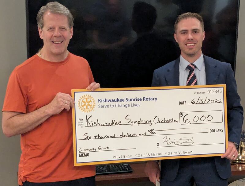 Kishwaukee Symphony Orchestra music director Linc Smelser (left) accepts a donation for the KSO’s Instrument Donation project from Kishwaukee Sunrise Rotary Club president Kevin Sullivan.
