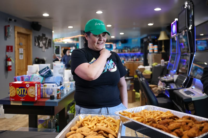 Manager Amanda Jolly pauses for a moment as a donated meal, Marques Covington, owner of Mac’s BBQ Food Truck, arrives at the Fun Hub on March 12, 2026. The small bar transformed into a bustling hub of supplies, food and resources following the March 10 tornado that caused destruction in Aroma Township and across Kankakee County.