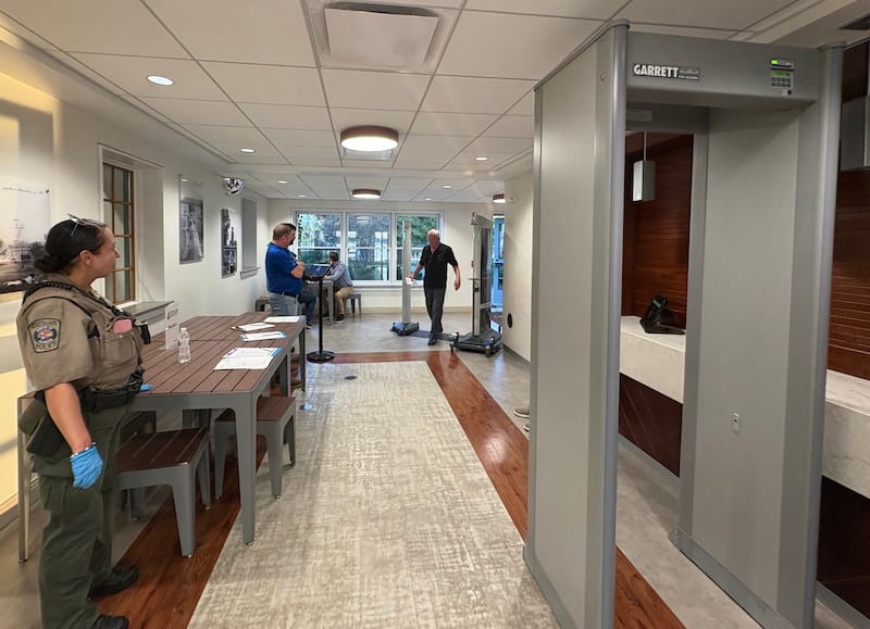 A Crystal Lake Park District police officer stands next to a metal detector set up for a park board meeting Sept. 22, 2025., prompted by security concerns.