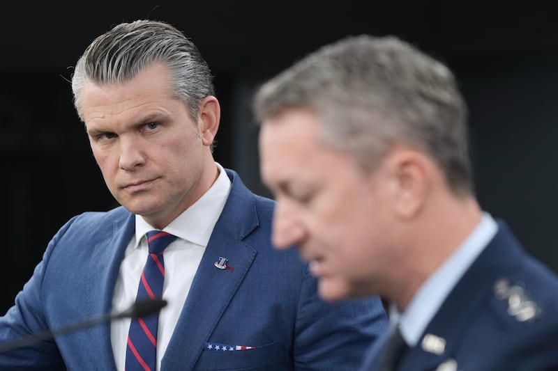 Defense Secretary Pete Hegseth listens to Chairman of the Joint Chiefs of Staff Gen. Dan Caine, during a press briefing at the Pentagon, Monday, March 2, 2026, in Washington. (AP Photo/Mark Schiefelbein)