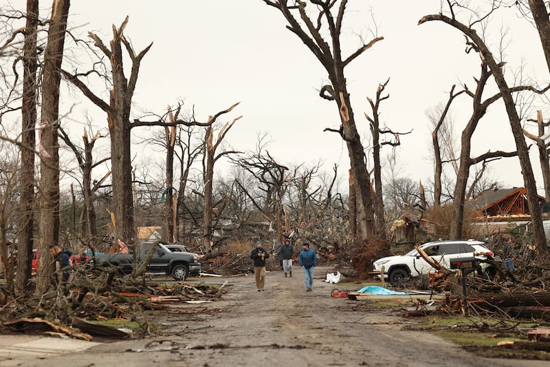 Residents walk along Elmwood Drive to check on each other in Aroma Park  on March 11, 2026 following a March 10 tornado that passed through Kankakee County.