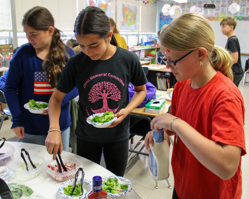 Students prepare a fresh salad using vegetables they grew in their school garden.