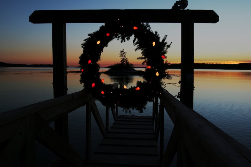 FILE - This Tuesday, Dec. 18, 2007 file photo shows a Christmas wreath decorated with lights at the end of a dock at sunset on Linekin Bay in East Boothbay, Maine. Wintertime can trigger true but transient depression in some people, a condition sometimes called Seasonal Affective Disorder. It's linked with lack of sunlight in winter and some scientists think affected people overproduce the sleep-regulating hormone melatonin. Research suggests it affects about 6 percent of the U.S. population and rates are higher in Scandinavia. But contrary to popular belief, suicides peak in springtime, not winter. No one has figured out why. (AP Photo/Pat Wellenbach)