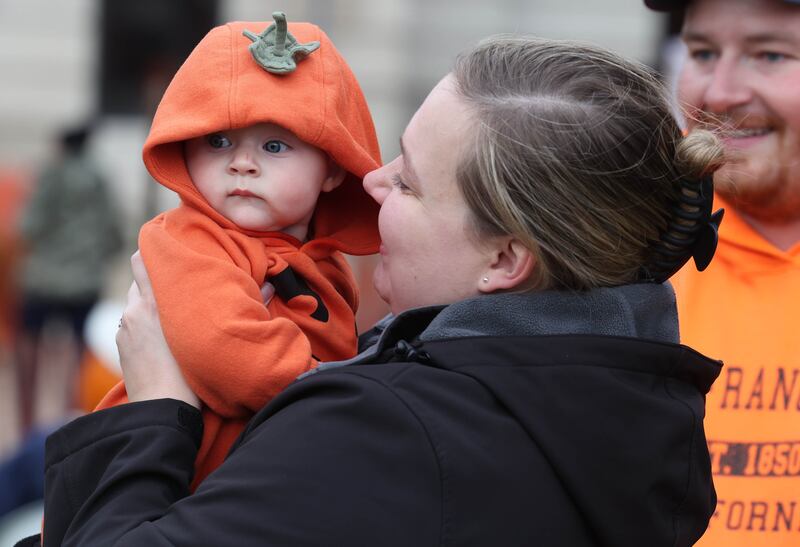 Remington Buettner, 6 months, looks around the festivities along with mom Daniele, from Sycamore, Wednesday, Oct. 22, 2025, during opening day of the Sycamore Pumpkin Festival.