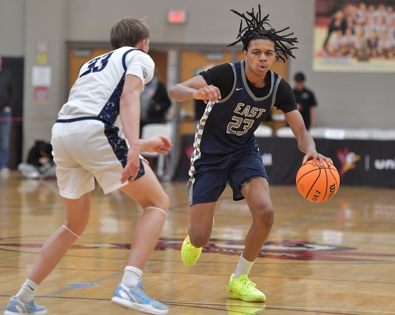 Oswego East’s Mason Lockett (23) drives as New Trier’s Elton Jaegerskog (33) defends during a When Sides Collide Shootout game on January 24, 2026 at Benet Academy in Lisle.