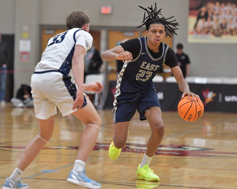 Oswego East’s Mason Lockett (23) drives as New Trier’s Elton Jaegerskog (33) defends during a When Sides Collide Shootout game on January 24, 2026 at Benet Academy in Lisle.