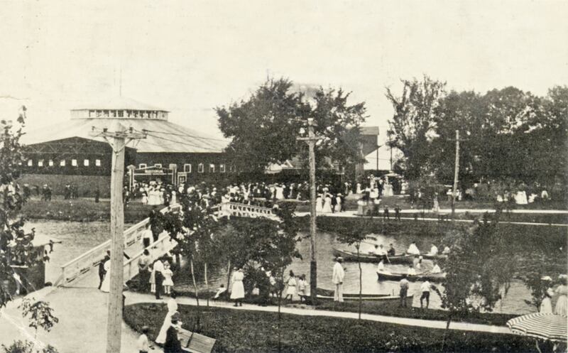 Riverview Park, from the roof of the pavilion on the island looking towards shore, with boats and strollers. Although this postcard is postmarked 1911, the name of the park was changed to Fox River Park about 1905.