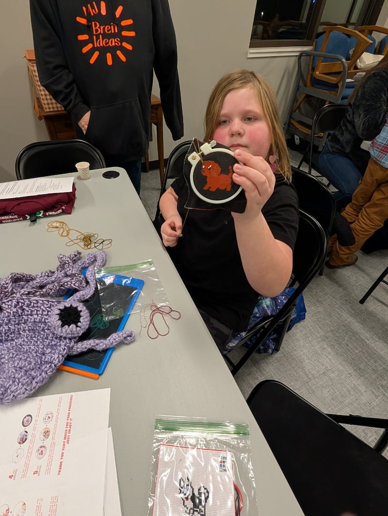 Jaylee Breit, Hub Hickory Nuts 4-H Club, working on her cross-stitch project.