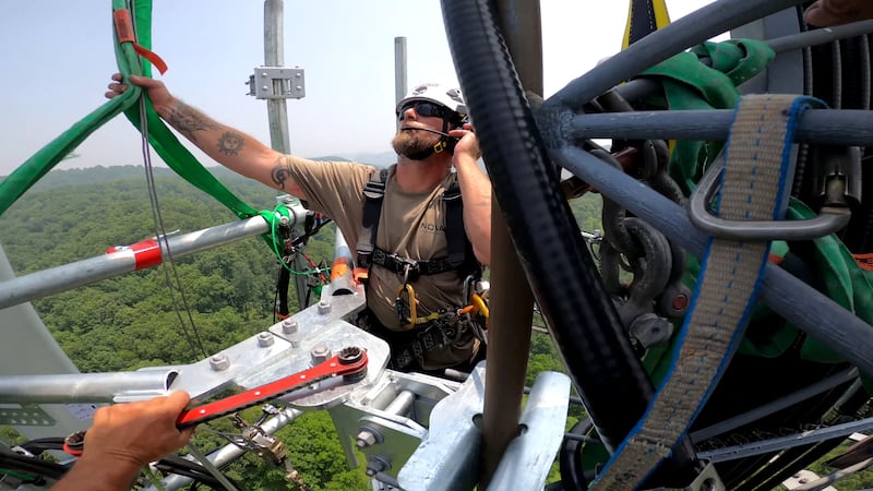 Tower climber William Stone doing a sector mount change-out with a helicopter on a mountain site in Kenna, West Virginia.
